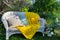 Lovely place for rest in green garden - white  wicker couch with yolk-yellow blanket and two different cushions