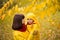 Lovely pretty young mother and little 4-years old daughter admire a beautiful tree with golden autumn leaves, smiling