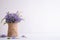 Lovely purple flower in sack vase on white wooden table