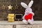 Lovely rabbit doll holding red heart sitting near gift box