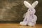 Lovely rabbit doll sitting on wood near wood wall