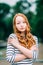 Lovely red-haired girl hugging herself and looking at camera