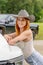 A Lovely Red Headed Cowgirl Poses In A Country Western Setting Outdoors Against Her Truck