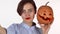 Lovely red lipped woman taking selfies with carved Halloween pumpkin