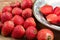 Lovely red strawberries arranged on the brown board with some sliced on the white gold stripe ceramic saucer