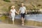 Lovely senior mature couple on their 60s or 70s retired walking happy and relaxed on beach sea shore in romantic aging together