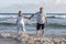 Lovely senior mature couple on their 60s or 70s retired walking happy and relaxed on beach sea shore in romantic aging together