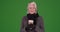 Lovely senior woman holding coffee cup enjoying cold winter day on greenscreen