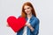 Lovely and shy, cute redhead teenage girl confess sympathy, give present on valentines day, handmade red heart, smiling