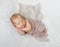 Lovely sleeping baby covered with light knitted shawl