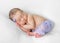 Lovely sleeping newborn with hands under head in violet panties