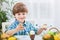 Lovely smiling child painting eggs