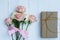 Lovely soft orange pink color rose tied by pink ribbon and brown gift box on white wood table background, sweet valentine present