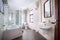 A lovely spacious light color tiled family or hotel bathroom with spotlights over a bath cabinet