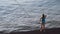 Lovely sporty woman llooking at the rippled sea surface. Concept. Rear view of a woman standing on the edge of a pier