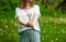 Lovely summer picture of a woman holding dandelion against grass background