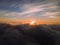 A lovely sunset over the clouds. The rays of the sun beautifully pass through the clouds. Above the sky. Shooting at high altitude