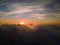 A lovely sunset over the clouds. The rays of the sun beautifully pass through the clouds. Above the sky. Shooting at high altitude