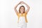 Lovely tender friendly young girl with blond hair, wear summer yellow t-shirt, overalls, raise hands up show heart sign