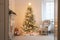 lovely traditional christmas tree surrounded by ornaments and lights, in white hokey room