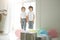 Lovely twins. Two cute latin twin boys, little children in casual wear looking happy, greeting their parents, preparing