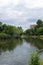 Lovely view of the lake and gorgeous trees in finsbury Park, cloudy grey sky above.