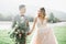 Lovely wedding couple, bride and groom posing in field during sunset