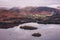 Lovely Winter sunrise landscape image of view from Walla Crag in Lake District towards distant mountains with low cloud