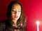 Lovely woman gazes in candle light as she anticipates Valentine`s day
