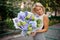 Lovely woman holding a pretty composition of flowers