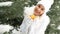 Lovely woman offers tangerines against background of winter landscape