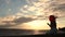 Lovely woman with red balloon on seaside at sunset