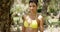 Lovely woman in yellow bikini standing near tree