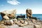 Lovely young adult couple on the rocks in the sea near the beach with big cliffs, Black Sea, Odessa, Ukraine, place for text set