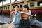 A lovely young Asian tourist couple enjoys talking on a bench on the platform