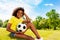 Lovely young black curly girl with football ball