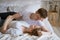 Lovely young caucasian couple on white blanket on white bed in room beds