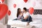 Lovely young couple in decorated with heart shaped balloons. Valentine`s day celebration