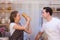 Lovely young happy caucasian couple or lover playful fight in kitchen together. Funny boyfriend and girlfriend have fun in kitchen