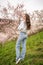 Lovely young woman in a blooming pink and white garden Petrin in Prague, spring time in Europe