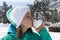 Lovely young woman kissing snow heart