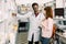 Lovely young woman smiling, buying medicines at the drugstore. African man pharmacist helping his female customer