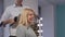 Lovely young woman smiling, while getting her hair styled by hairdresser