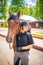 Lovely young woman wearing helmet stroking to her brown horse