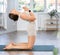 Lover of active lifestyle on yoga mat perform doing camel pose in gym