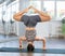 Lover of active lifestyle on yoga mat perform doing shirshasana in gym