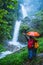 Lover asian man and asian women travel nature Travel the highest waterfall in Chiangmai Mae-pan waterfall rainy season at Doi