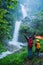 Lover asian man and asian women travel nature Travel the highest waterfall in Chiangmai Mae-pan waterfall rainy season at Doi