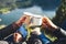 Lovers couple hold in hands mug of hot drink, enjoy together of sun flare mountain, travelers drink tea on cup on nature, romantic