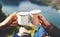 Lovers couple hold in hands mug of hot drink, enjoy together of sun flare mountain, travelers drink tea on cup on nature, romantic